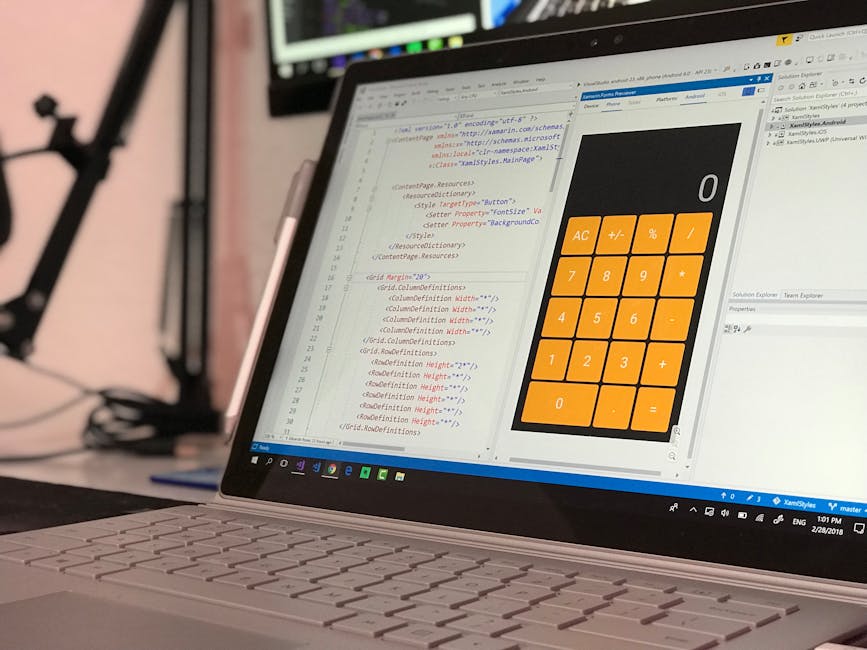 A laptop open on a desk displaying a coding environment with HTML and CSS code on the left side and a large calculator graphic on the right side. The screen shows various lines of code in a text edito